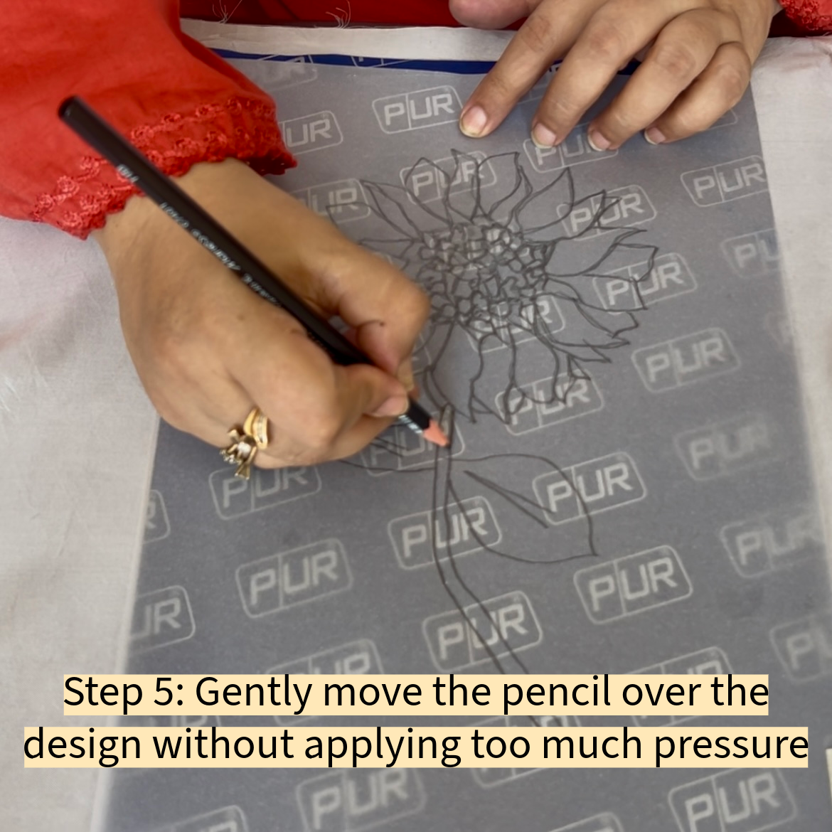 Gently move the pencil over the design without applying too much pressure.