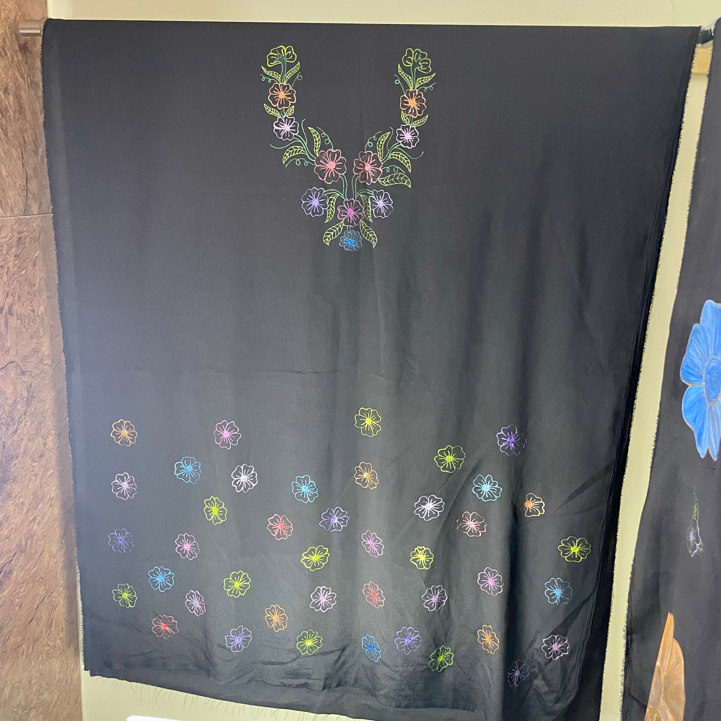 Dark fabric with colorful floral embroidery patterns on a plain background