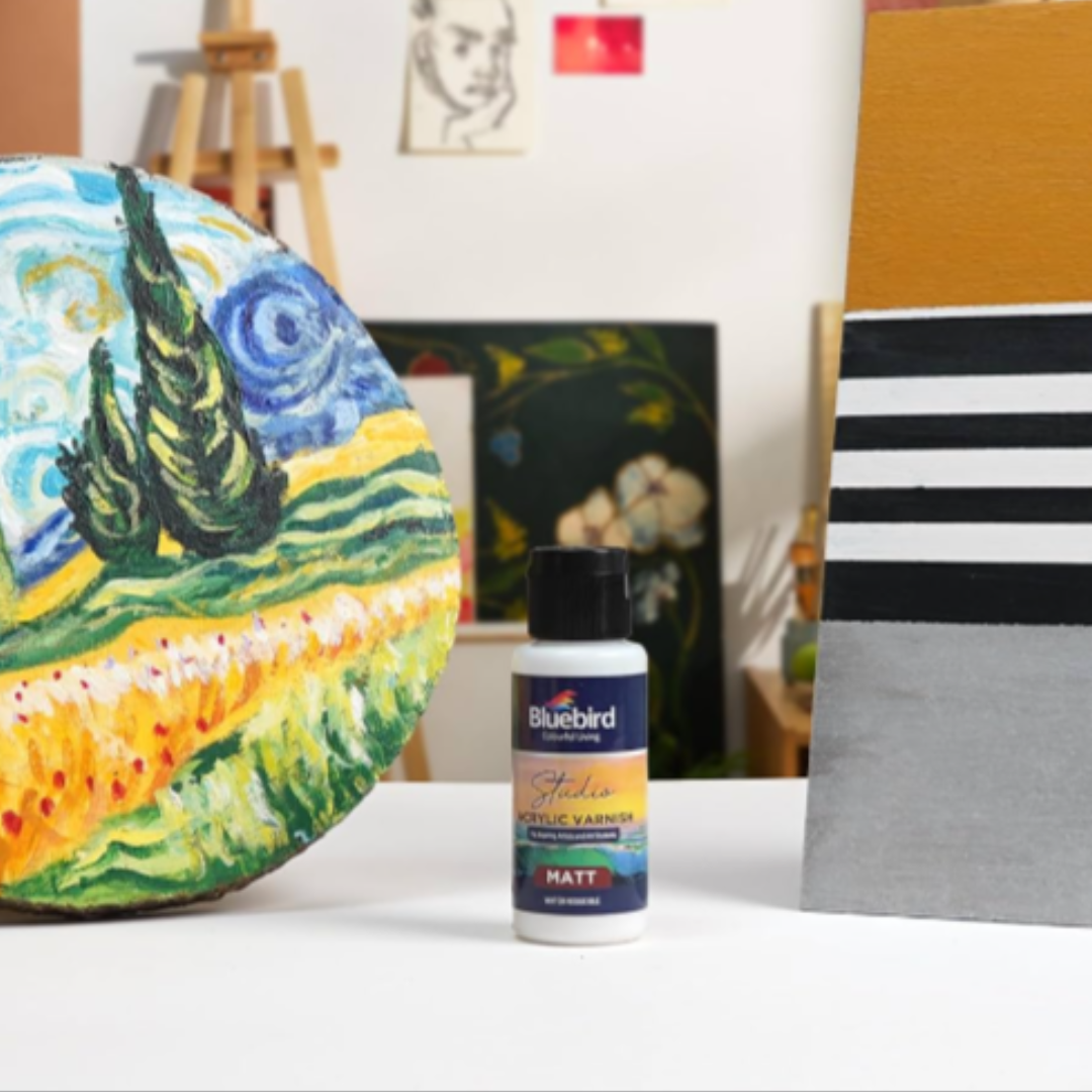 Bluebird acrylic paint bottle on a table with art supplies in the background